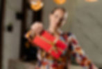A woman holding a gift card wrapped in red wrapping paper with a golden ribbon