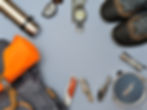 Essential hiking gear arranged on a blue background, including boots, compass, and flask.