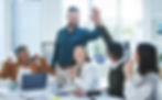 A team celebrating success in the office with a high-five, indicating a collaborative and joyful workplace.
