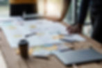 A planning session with a large whitepaper and post its