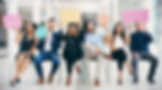 Colleagues sitting down and with talking bubbles made of paper