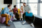 A group of colleagues sitting in a casual office setting, laughing and talking
