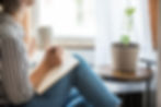 A woman having a mindful moment with a journal and a tea in her home