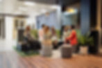 Group of colleagues having a meeting in a modern office lounge area.