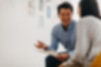 A man enthusiastically discussing ideas with a colleague, holding papers in hand.
