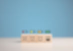 Wooden blocks with different smiley faces and battery levels, representing varying levels of energy or satisfaction.