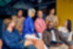 A diverse group of colleagues at a networking event, engaging in conversation and sharing ideas in a professional setting.