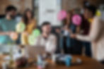 A group of people at work celebrating a colleague with balloons