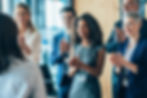 Group of professionals applauding a colleague in a business meeting or presentation.