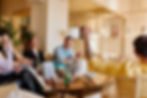 Group of friends laughing and celebrating together on a couch while playing a game in a living room.