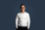 A business man standing with his hands inside his pockets
