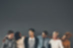 A diverse group of six individuals laughing and embracing, showcasing unity and friendship.