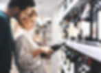 A couple searching for a wine bottle to buy in the grocery store