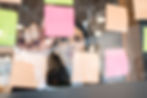 A woman writing on post its on a wall, in an ideation process