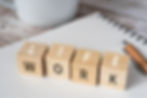 Wooden blocks on a desk spelling out 'LIFE WORK' balance concept.
