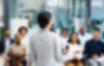 A woman talking in front of the team