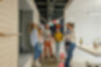 A group of coworkers at an office party, chatting and laughing with festive decorations and balloons in the background.