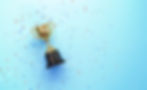 A golden trophy on a blue background, surrounded by confetti, symbolizing achievement and celebration.