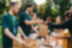 A group of volunteers handing out bags with goods to people that need them