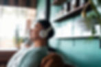 Man relaxing in an armchair with headphones, enjoying music.