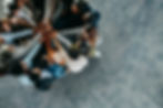 Overhead view of a diverse group of colleagues stacking hands in a gesture of teamwork and unity.