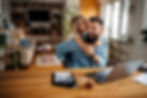 A man working from home is interrupted by her daughter, both smiling