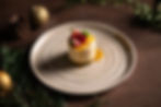 Elegant dessert plated with festive decor, topped with fruit and mint.