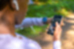 Person outdoors using a smartwatch and smartphone to track fitness data.