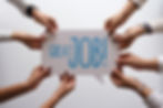 Hands of diverse individuals holding a speech bubble sign that reads Great Job! to celebrate success.