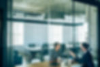 Two employees talking in a meeting room