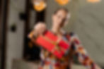 A woman holding a gift-wrapped gift card, handing it over