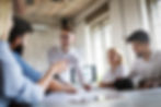 Colleagues discussing and smiling during a meeting