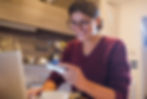 Smiling woman making an online purchase with a credit card in a cozy home environment.