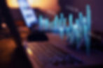 Close-up of a laptop with digital data and financial graphs superimposed on the screen