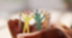 Colorful paper cutouts of people holding hands, symbolizing unity and community, held in someone's hands.
