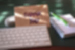 A thank you note on a work desk, next to a keyboard and notepad