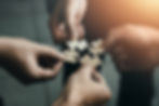 A picture of four people with a piece of a puzzle each, symbolising collaboration